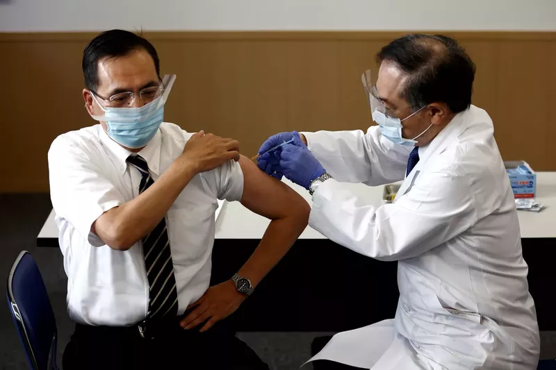 东京医学中心主任荒木一宏（L）将于2021年2月17日在东京发起接种运动时，接受一剂Covid-19疫苗。.webp